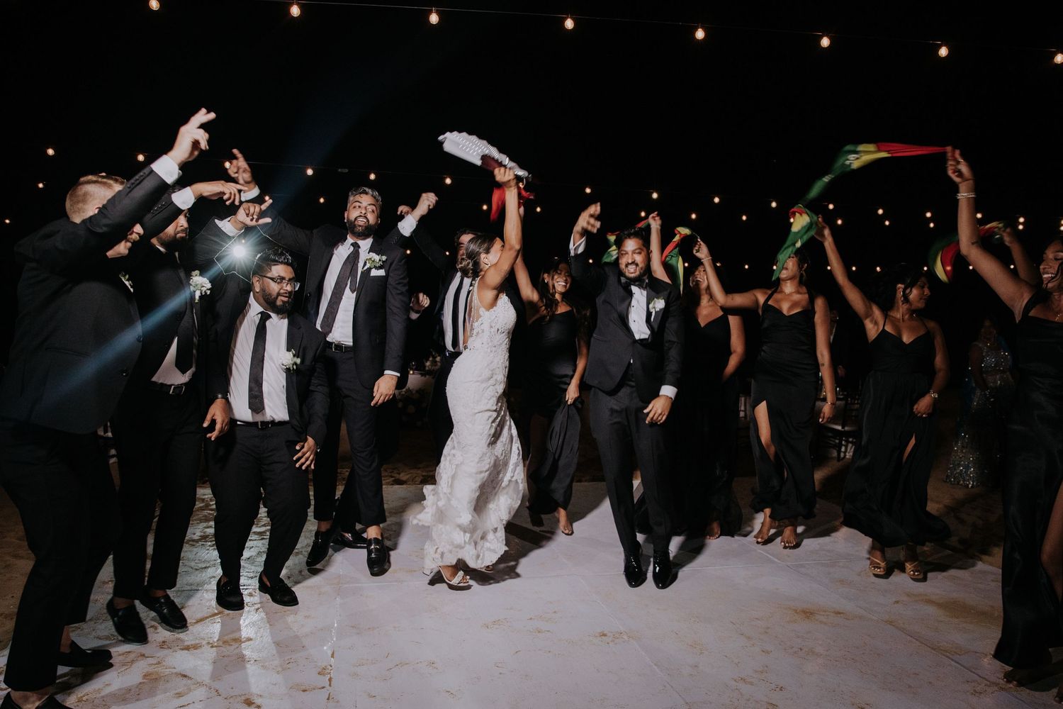 Wedding party performs coordinated dance moves during an evening reception.