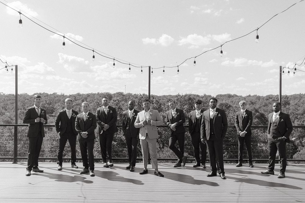 Wedding guests gather outdoors under string lights during an evening celebration.
