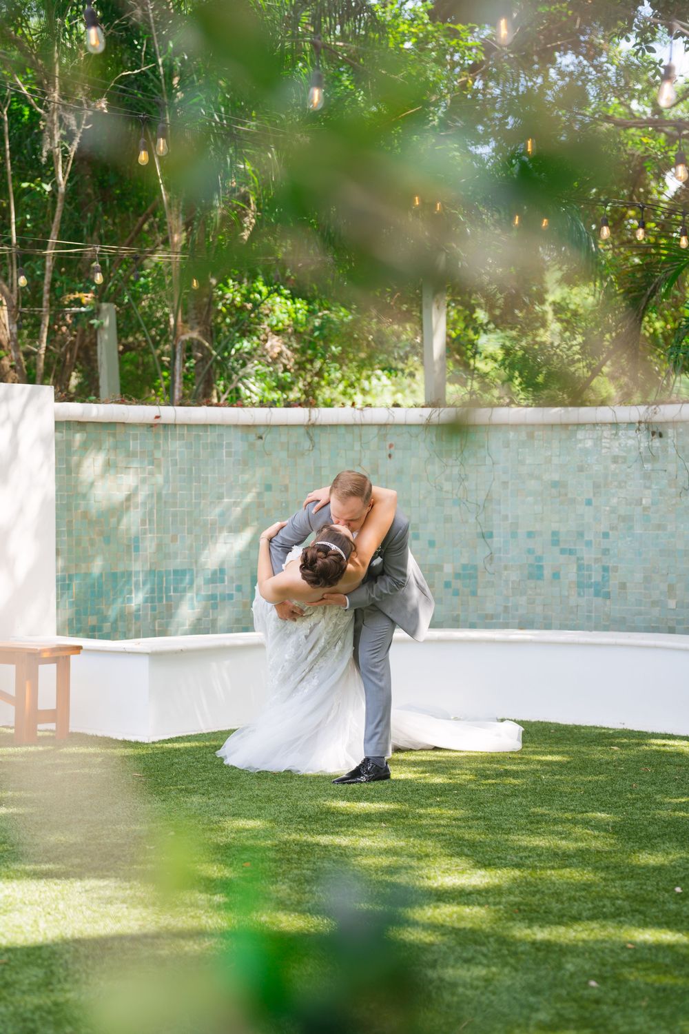 A romantic dip-style dance move on a grassy lawn with elegant wedding attire during golden hour.