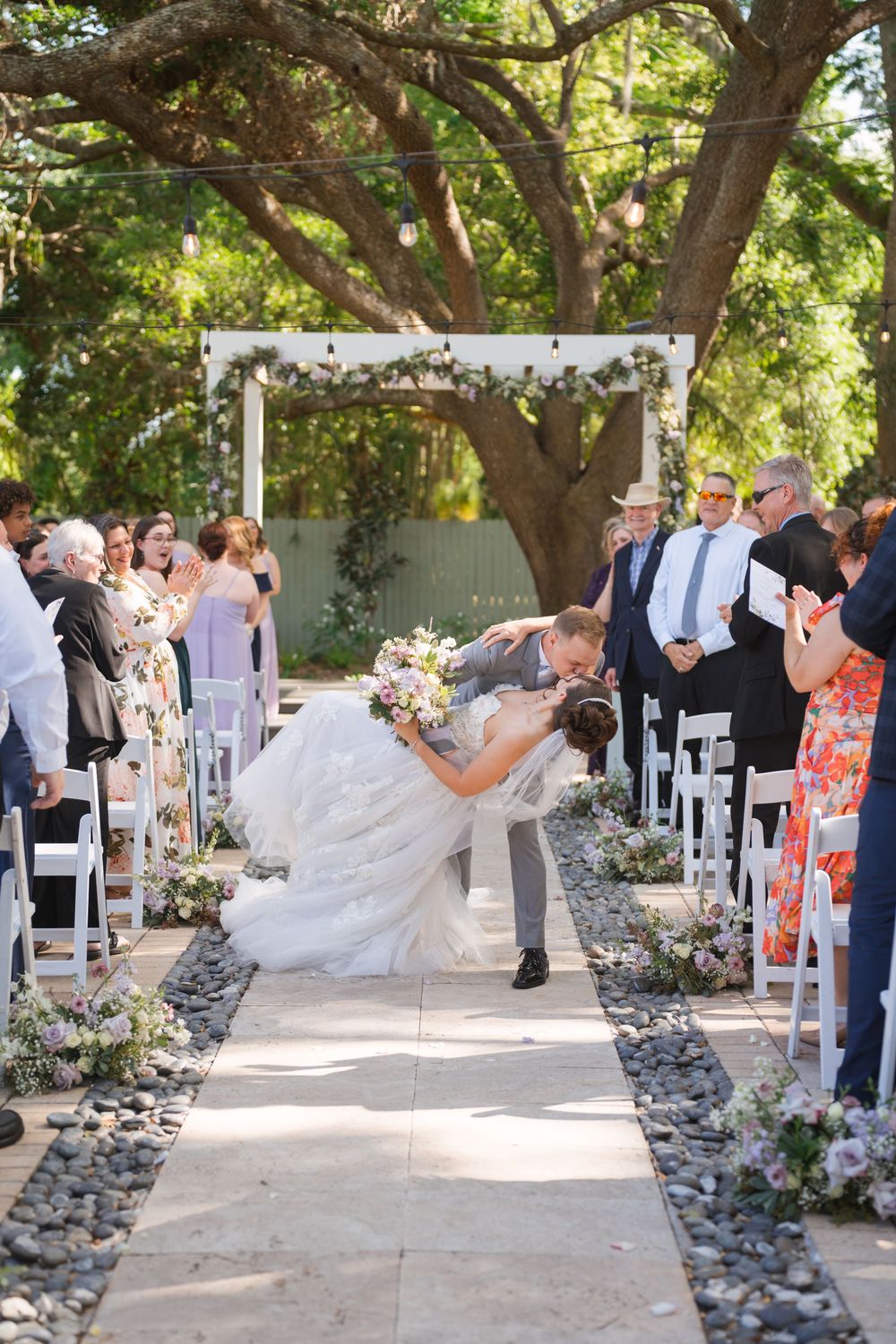 Multi-panel image sequence showing a wedding ceremony in a garden setting with white chairs and stone-lined pathway.