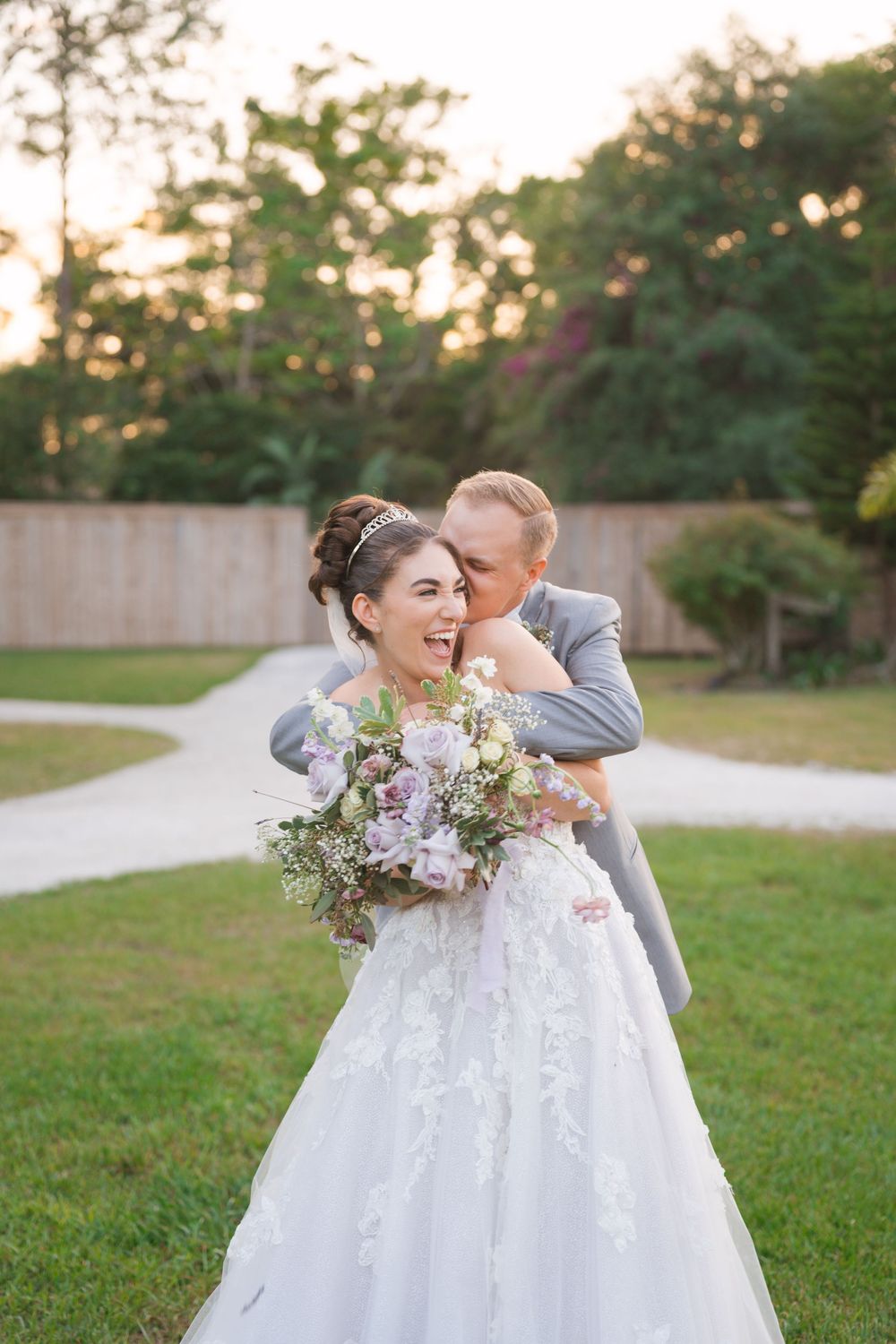 A joyful dancing moment captured in a sunlit garden setting with a flowing white gown.