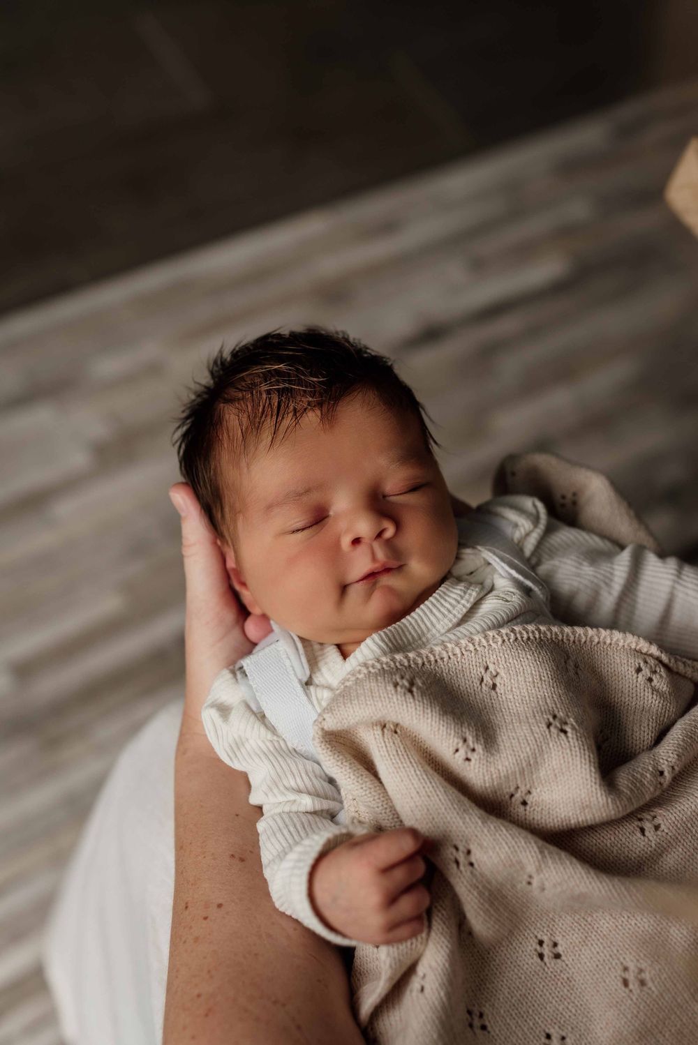 Baby smiling while sleeping in mother's arms, Sydney Hills District.