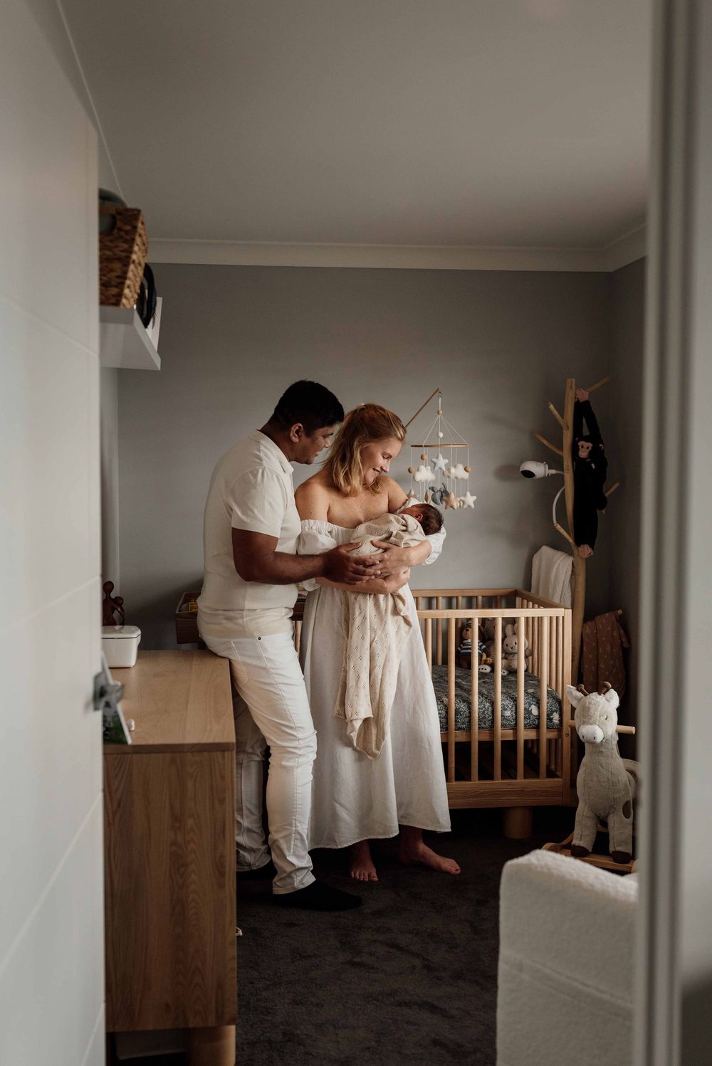 Mum holding baby boy in nursery during in-home newborn photography session in Sydney’s Hills District.