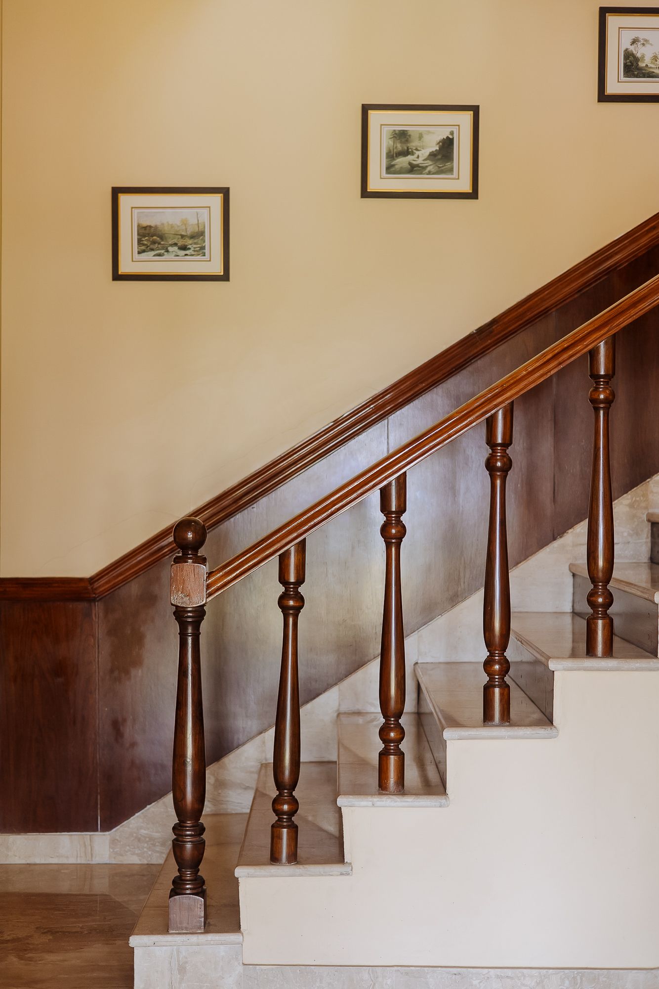 Wooden staircase with polished banister inside heritage hotel in the Himalayas.