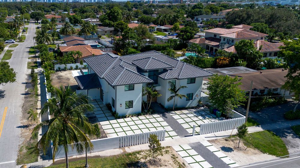 Bird's eye view of upscale waterfront properties with swimming pools and boat docks in Miami neighborhood.