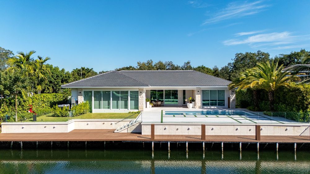Wide angle aerial view of waterfront mansions with private boat docks along Miami canal.