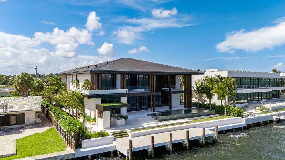 Scenic aerial panorama of Miami waterfront homes with boats docked along residential canal.