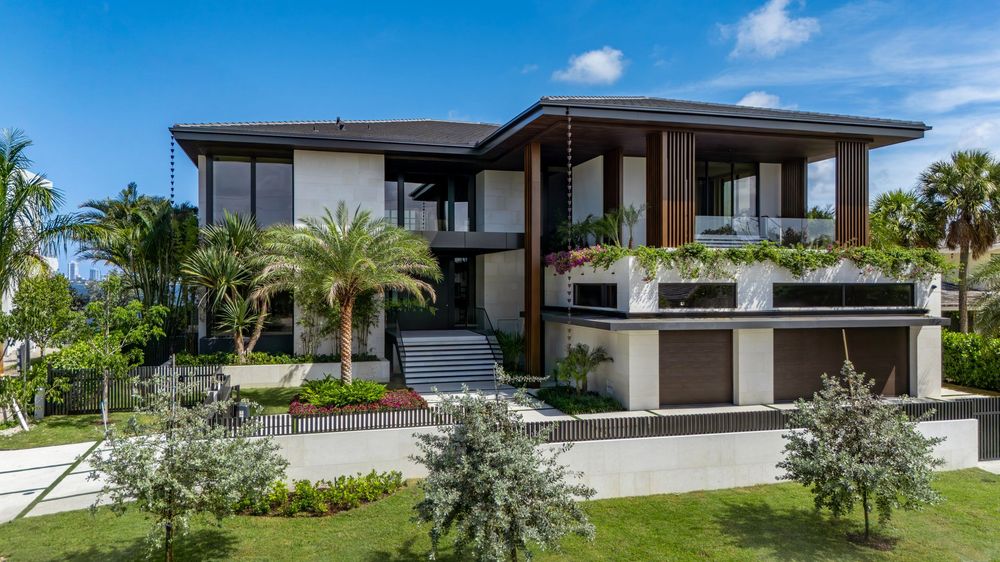 Aerial view of modern Miami waterfront homes featuring sleek architecture and landscaped gardens.