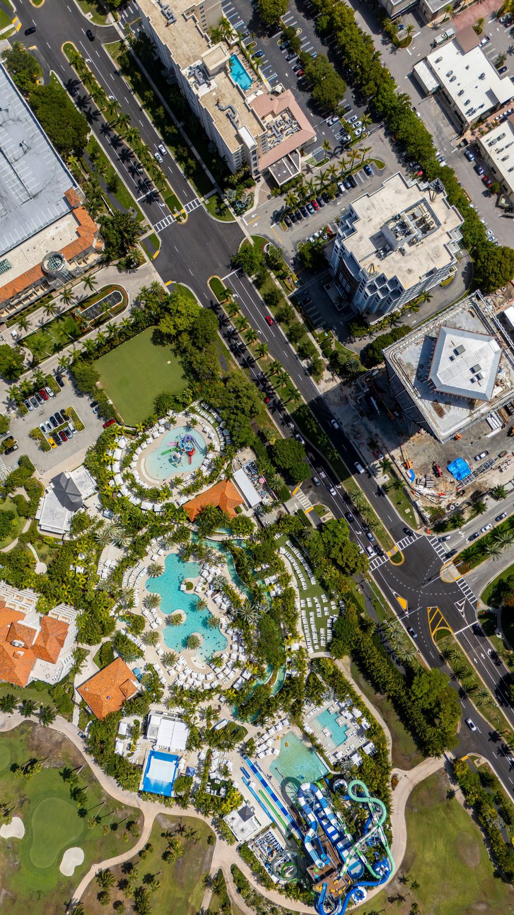 Aerial view of resort complex with multiple swimming pools and landscaped grounds.