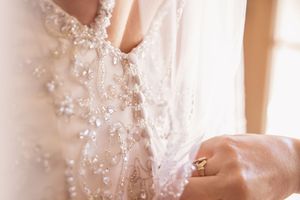 Close-up detail of intricate beading and lace on a wedding dress.