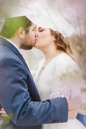 Romantic moment captured through delicate veil during wedding ceremony.