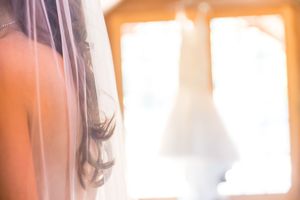 Soft window light illuminates bridal preparation room with warm glow.