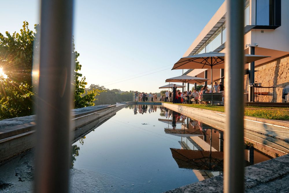 Stunning infinity pool reflection of a modern luxury villa during an outdoor evening event.