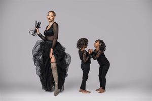 Artistic photo of a hair professional and children using dynamic poses in a studio setting.