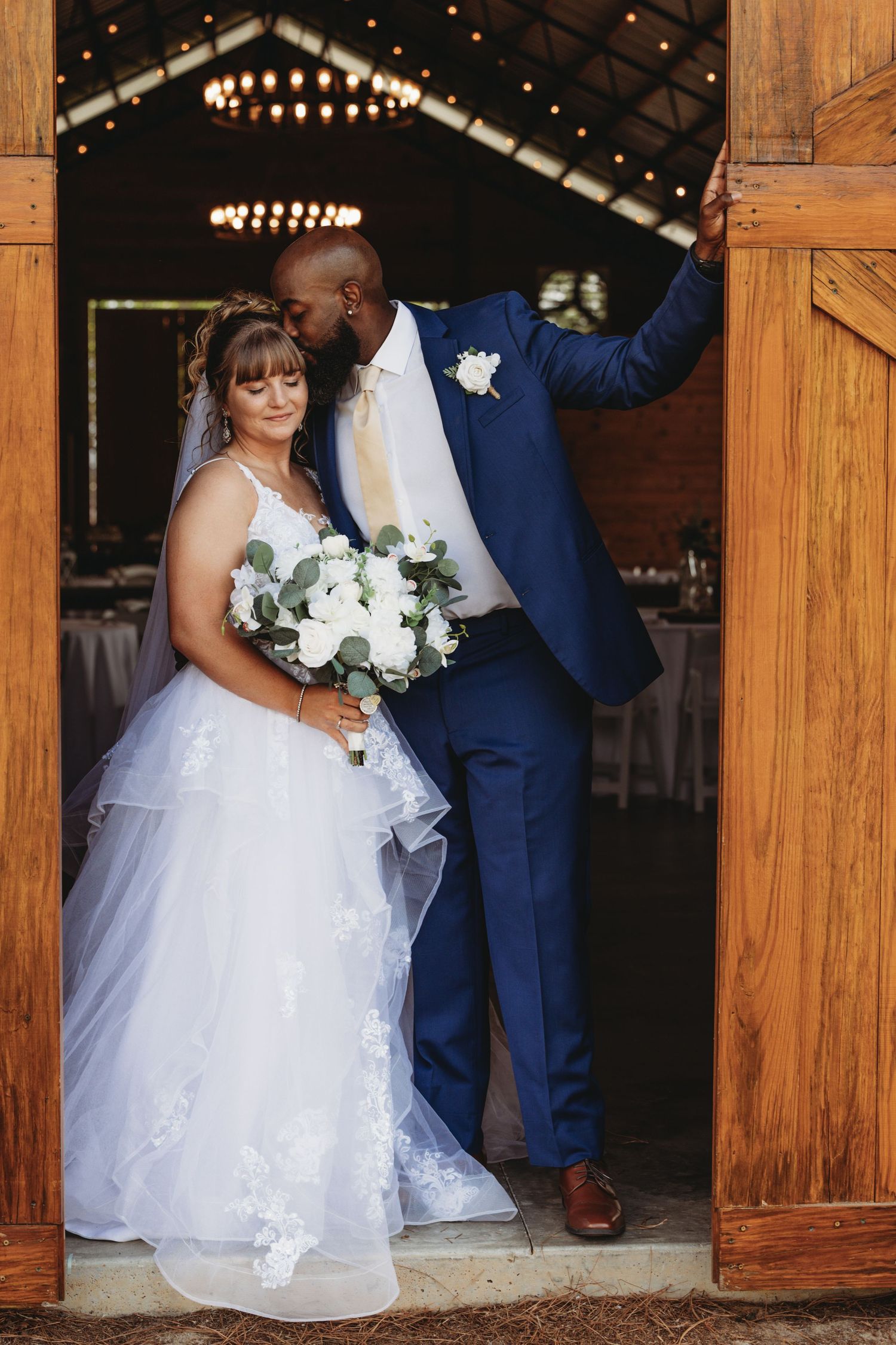 Wedding ceremony photos in a rustic wooden barn venue with string lights.