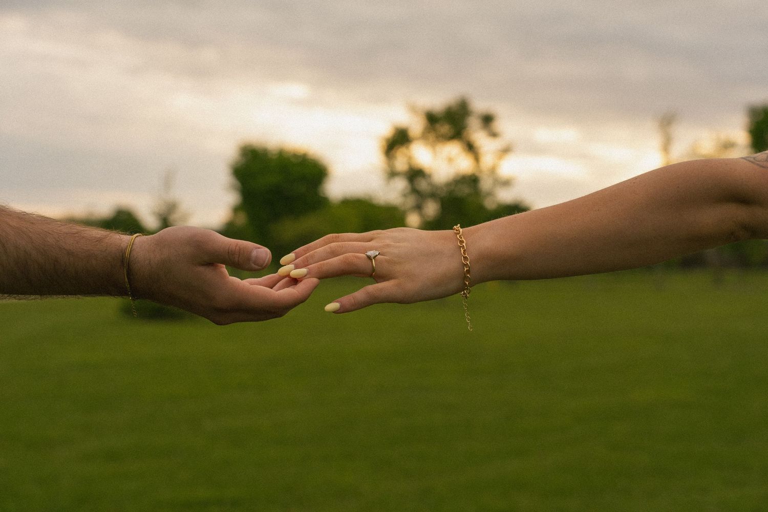 Soft focus shot of wedding party walking together in neutral colored attire outdoors.