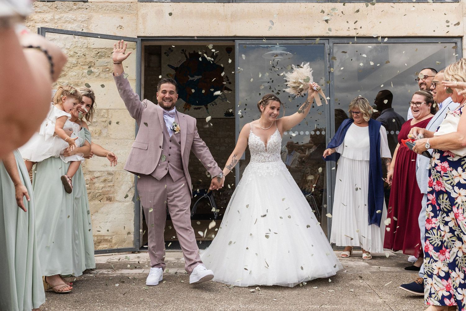 Sortie de cérémonie à la mairie de Chauray sous les acclamations des invités, photo de mariage dynamique et joyeuse dans le 79.