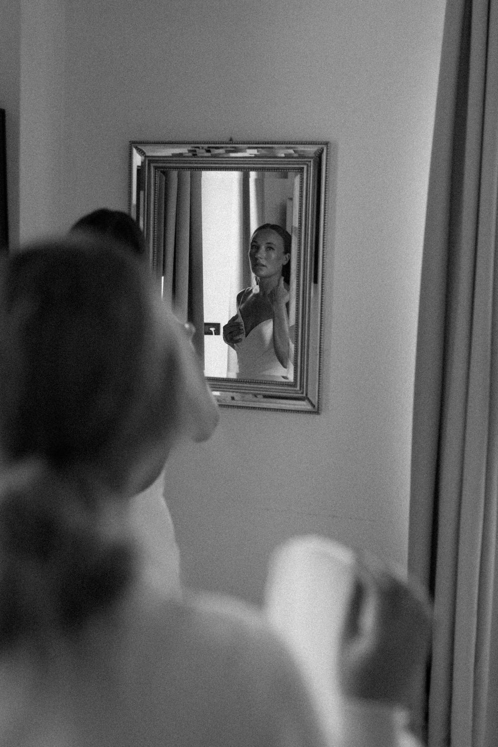 Bride looks in the mirror while she gets ready at Villa Belvedere Como Lake Argegno.