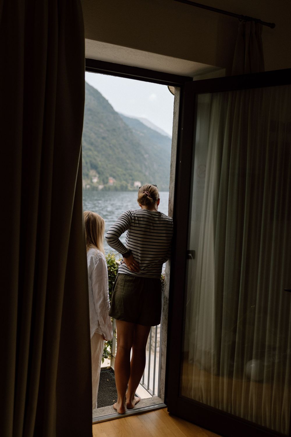 Bridesmaids look out across Lake Como from their hotel room at Villa Belvedere.