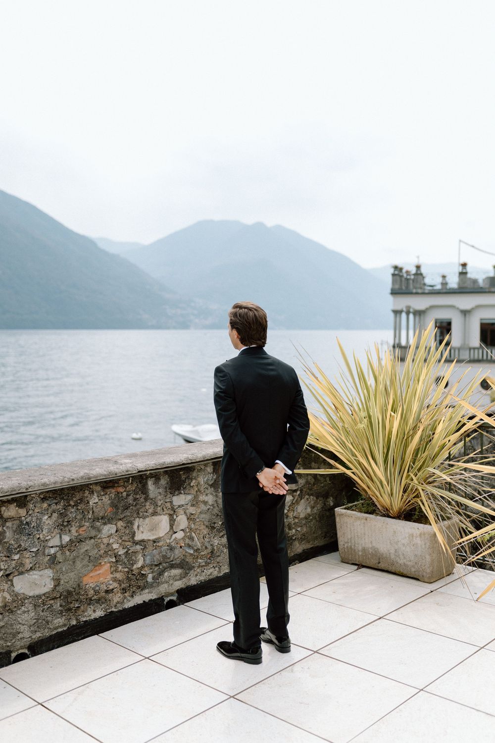 Groom waits for his bride for a first look on the terrace of Villa Belvedere Argegno Lake Como.