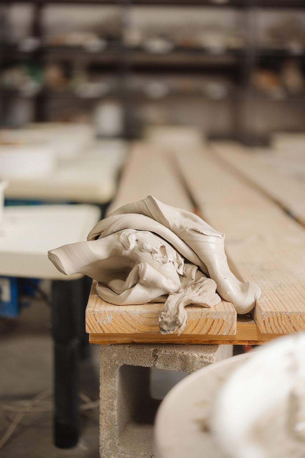 A crumpled beige cloth or fabric rests on a wooden table surface in an industrial or workshop setting.