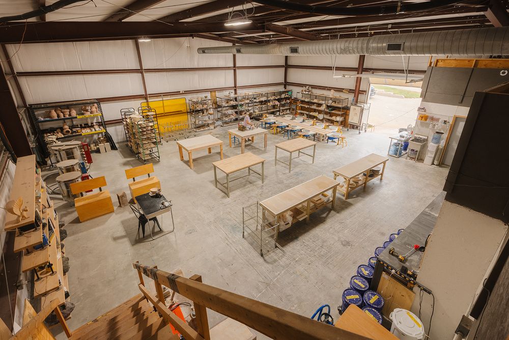 Spacious warehouse interior showing metal shelving units and inventory storage with high ceiling industrial lighting.