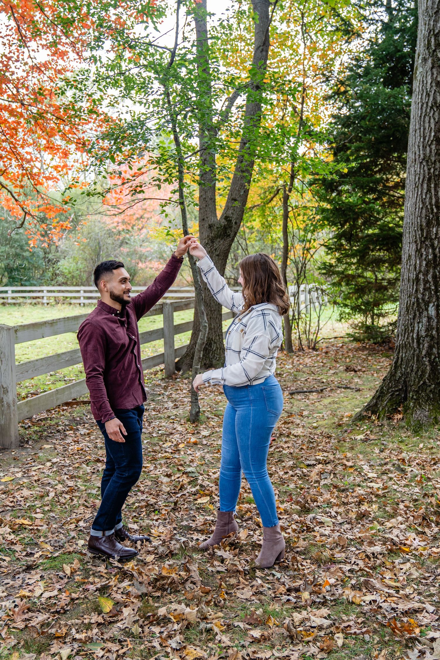 Couple dance together in a fall setting surrounded by colorful autumn trees. North Shore, MA mini sessions. Endicott Park, Couple sessions