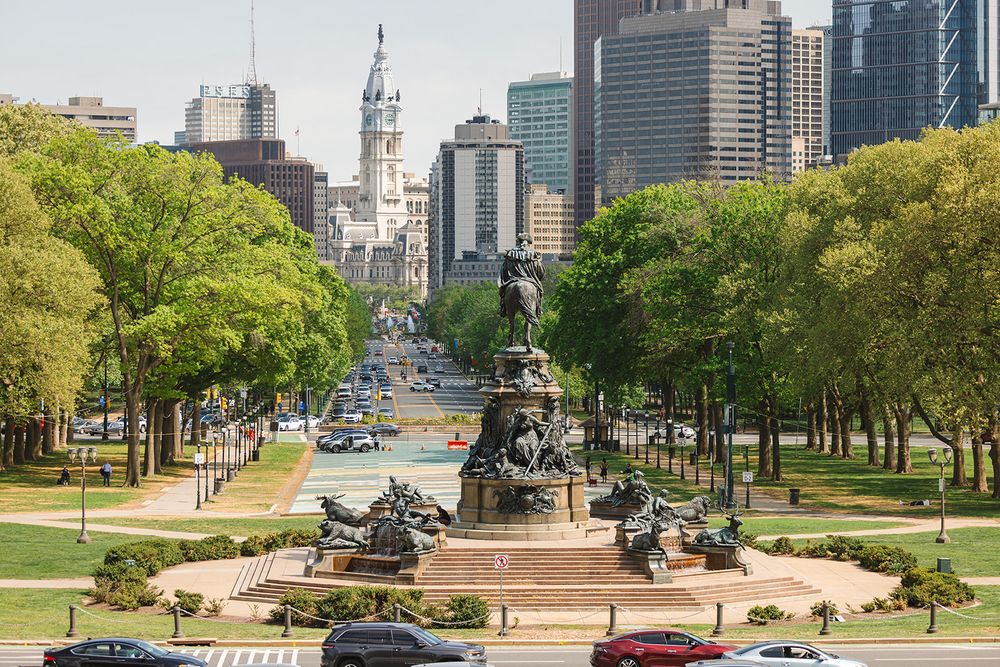View of Philadelphia's Benjamin Franklin Parkway with the Washington Monument Fountain and City Hall in the distance.