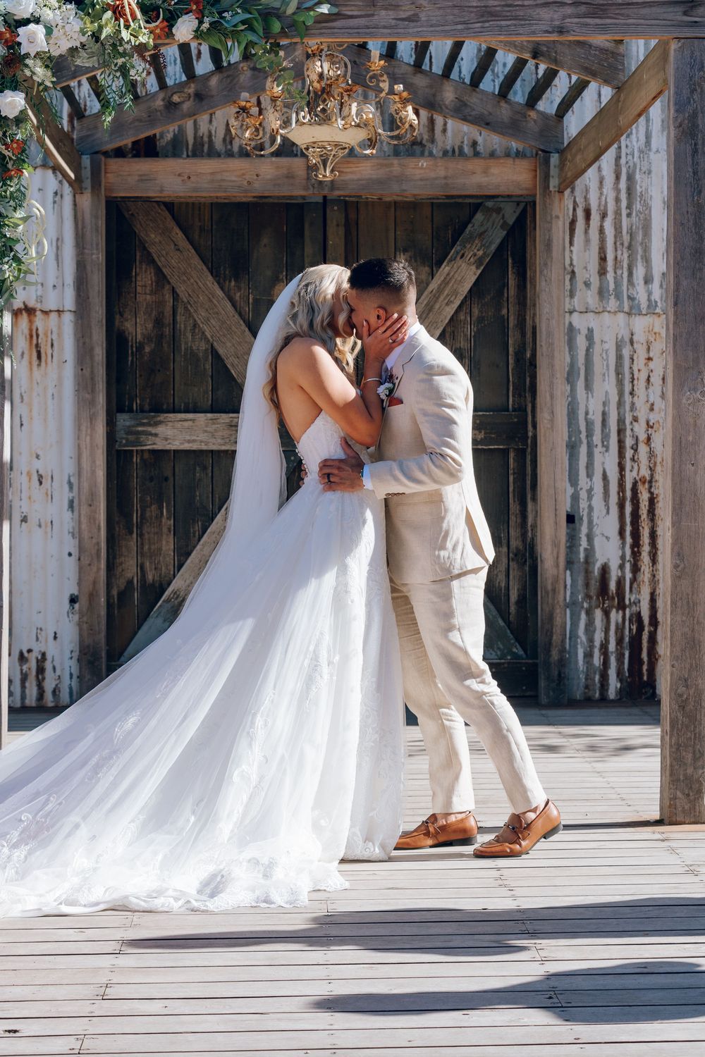 A romantic wedding photoshoot features flowing white dress trailing across rustic wooden floors.
