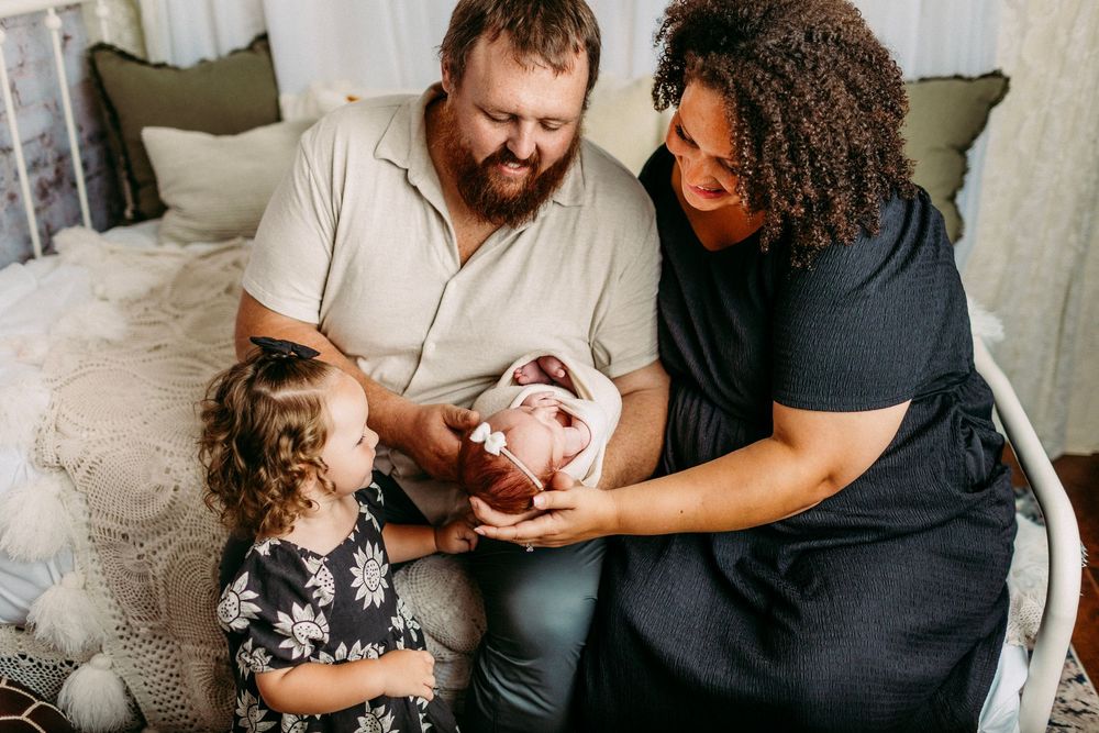 Intimate monochromatic family photoshoot showing tender moments and interactions between parents and child.