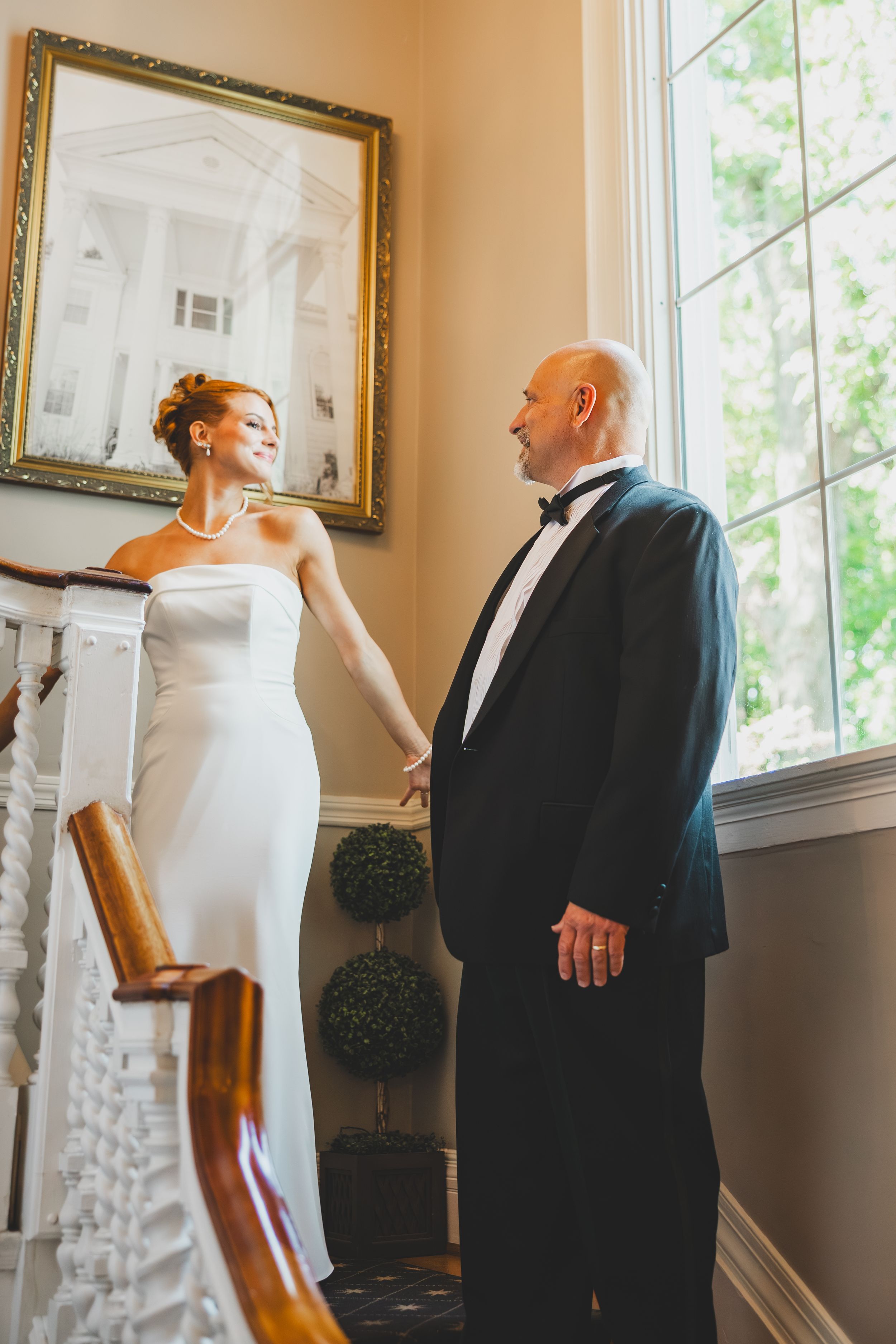 Bride and father first look photos on the staircase at the Overhills Mansion in Catosville, Maryland