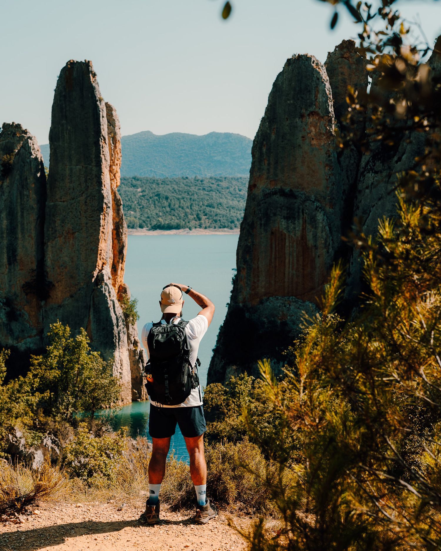Rocky outcrops overlooking a serene lake with mountains in the distance.