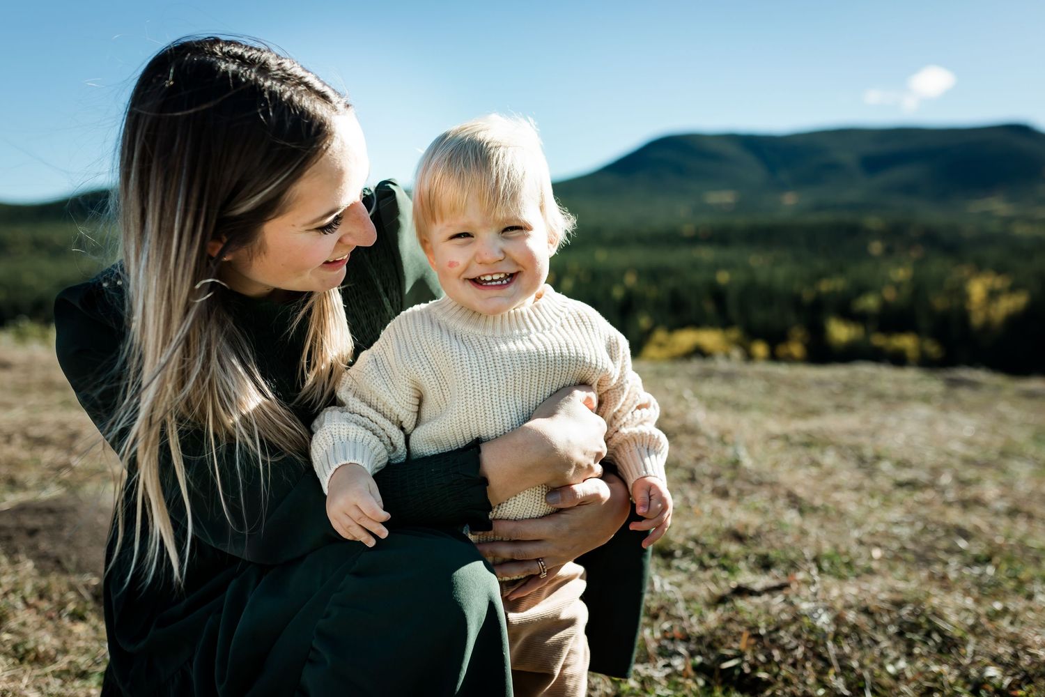 Beautiful motherhood moment during fall family photos in Kananaskis mountains by Calgary lifestyle photographer.