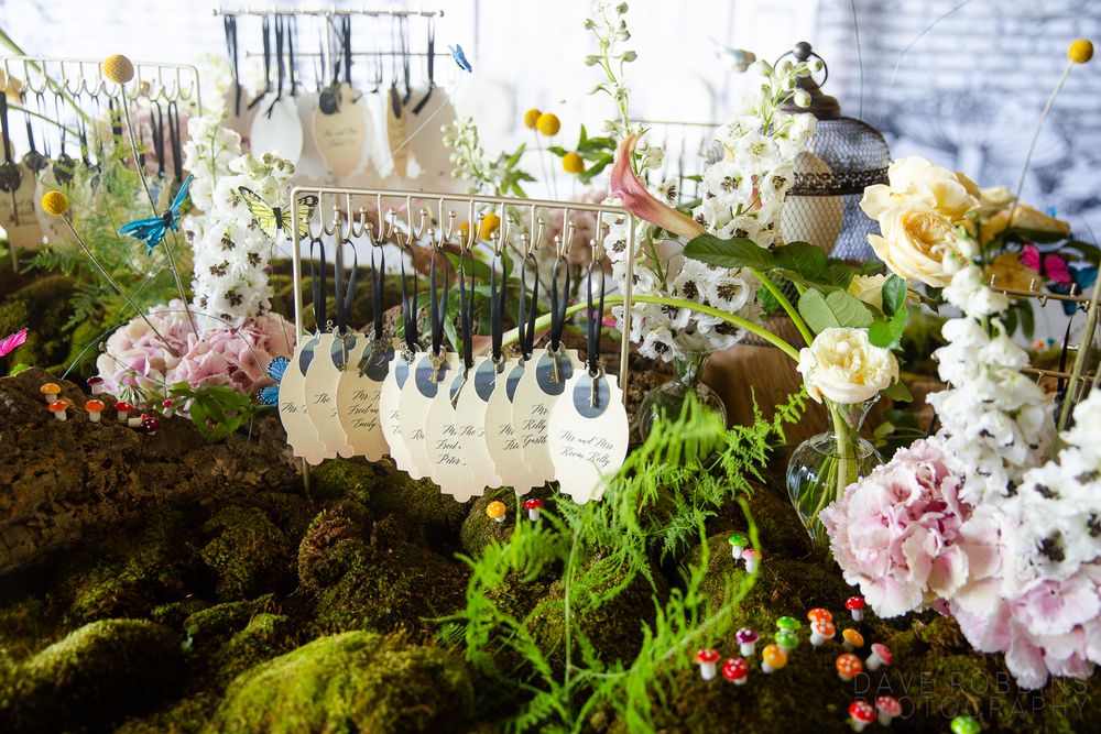 Wedding decorations with pink and white flowers arranged alongside delicate glass vases and greenery in a romantic display.
