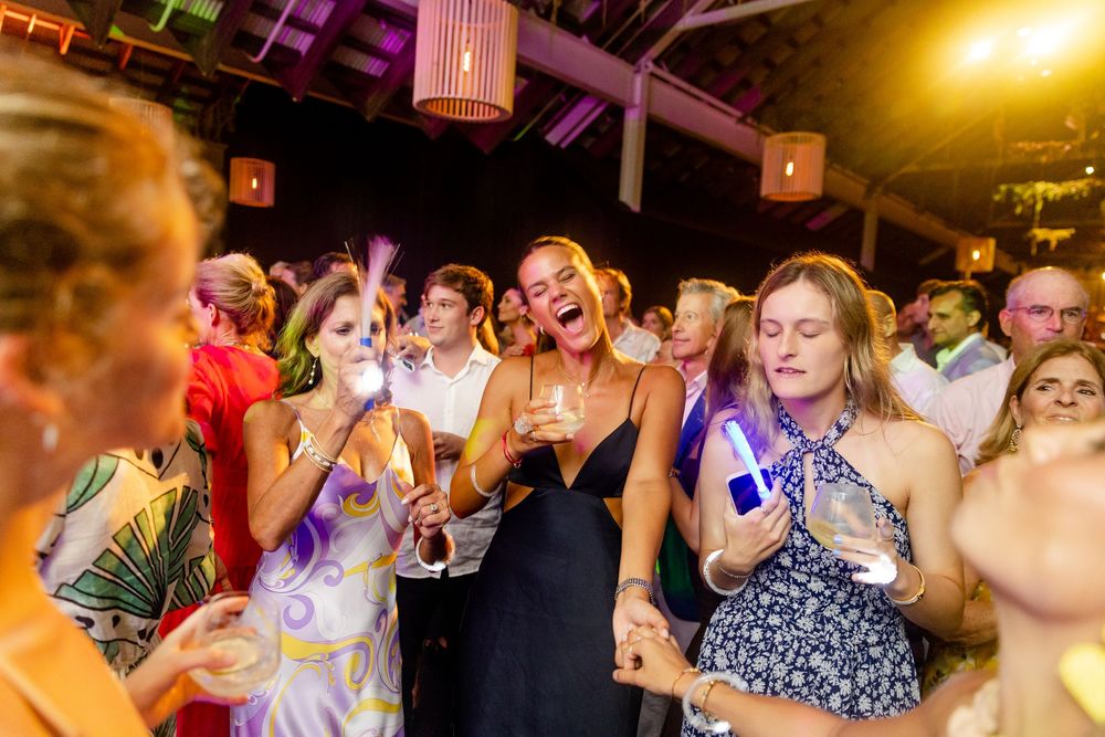 Enthusiastic party guests dancing and singing at a celebration event.