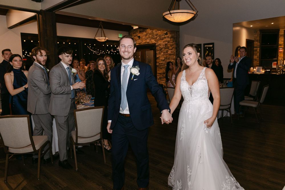 Couple sharing their first dance at a wedding reception in a rustic venue with stone walls and warm lighting.