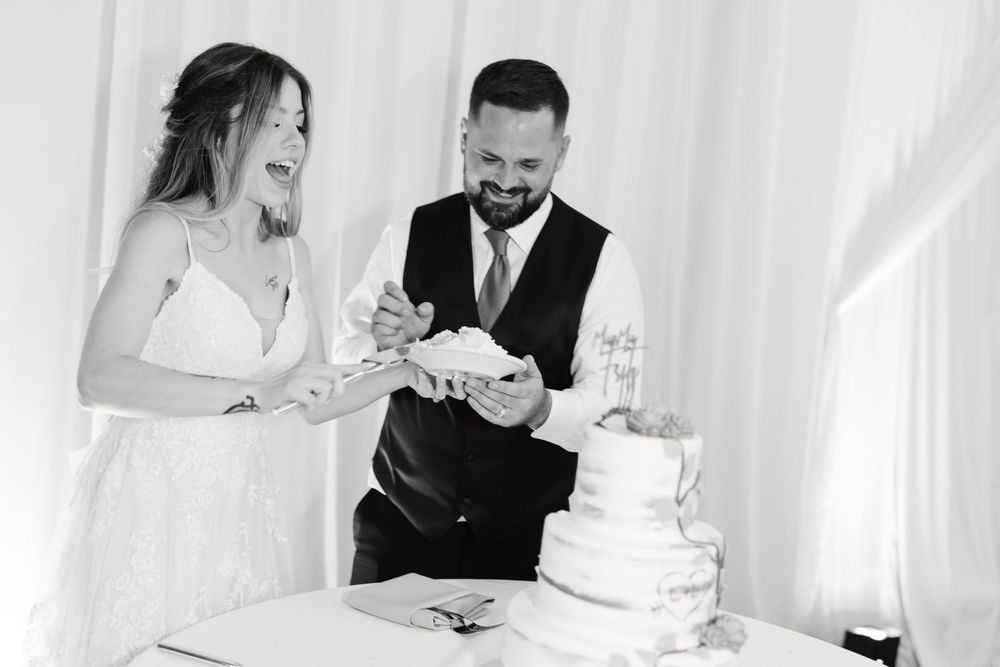 A couple shares an intimate moment while signing their marriage certificate at a wedding ceremony.