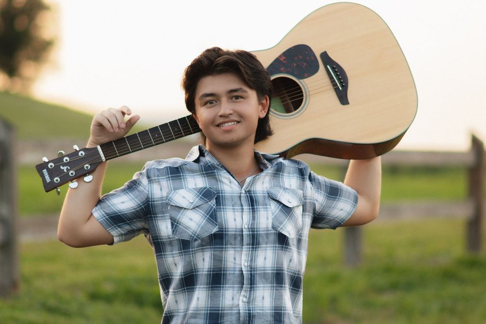 High school graduate with guitar at Celery Fields in Sarasota, Florida senior portraits.