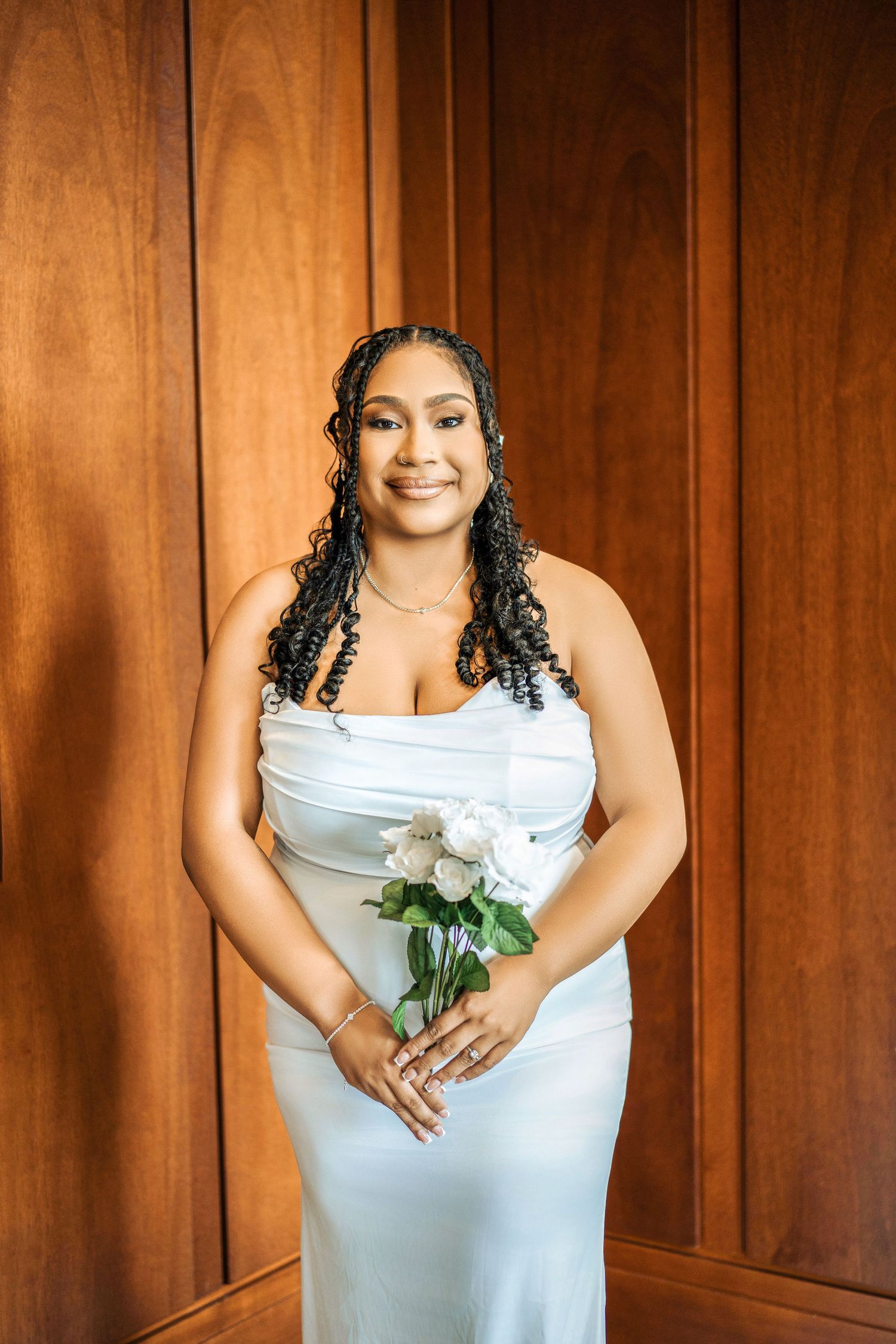 Four sequential photos show someone in a white dress holding white roses against a wooden paneled wall.