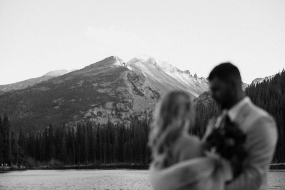 A black and white panoramic collage shows mountain landscapes with lakes and forests in a serene natural setting.