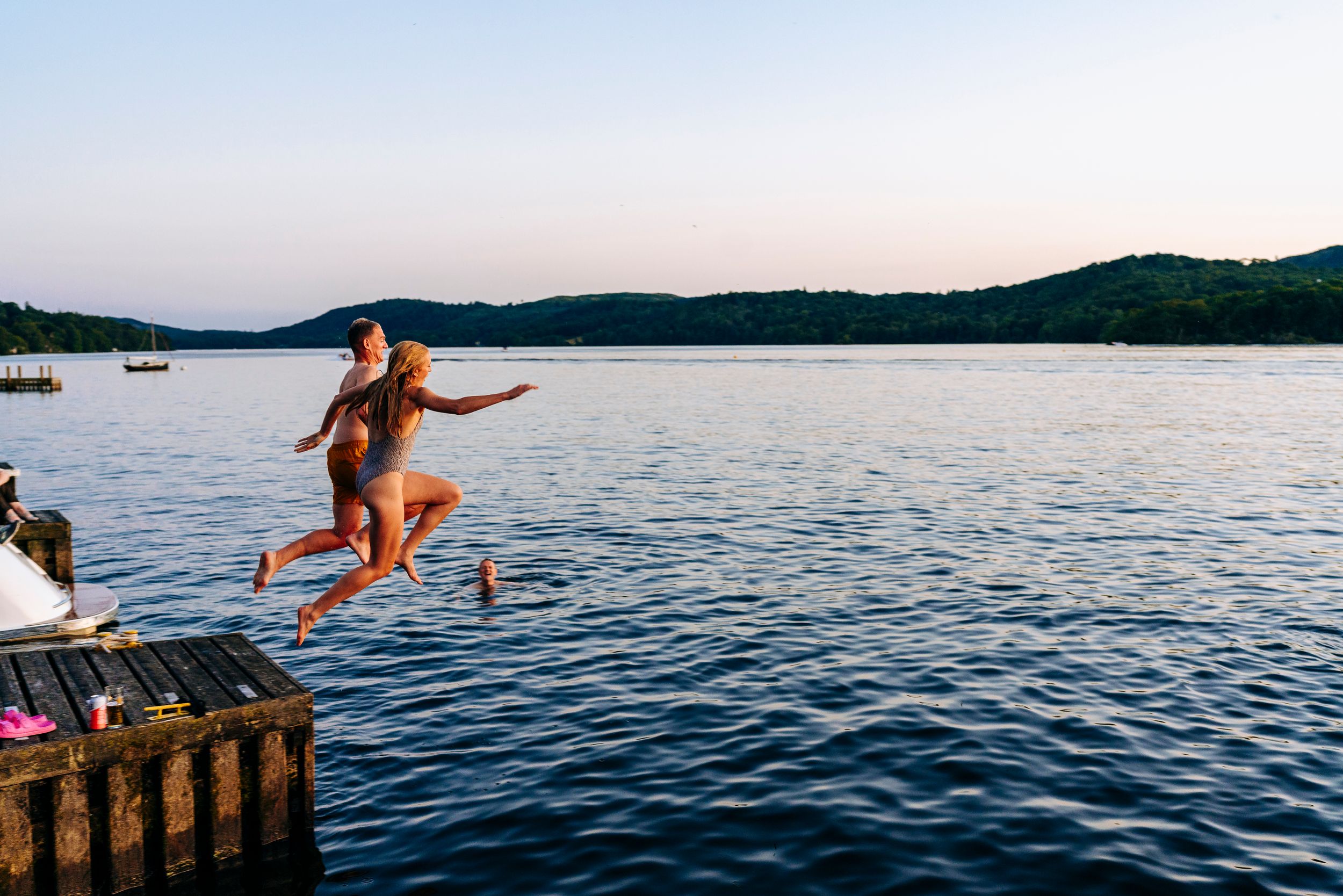 Bride and groom jumping into the water in Lake Windermere at a Lake District Wedding