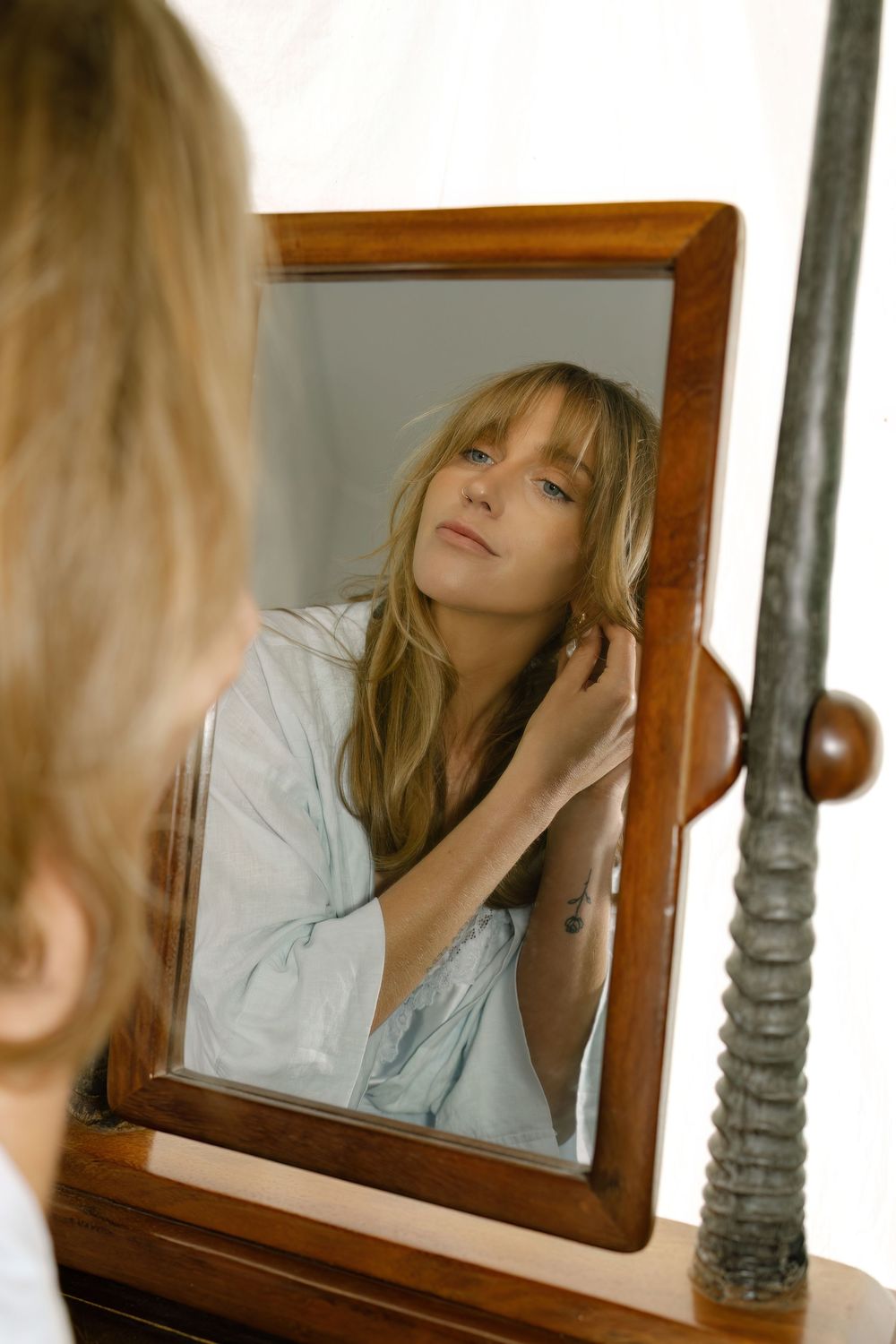 Artistic portrait reflected in multiple vintage mirrors showing contemplative expression and soft lighting captured by Danielle Conner Photo