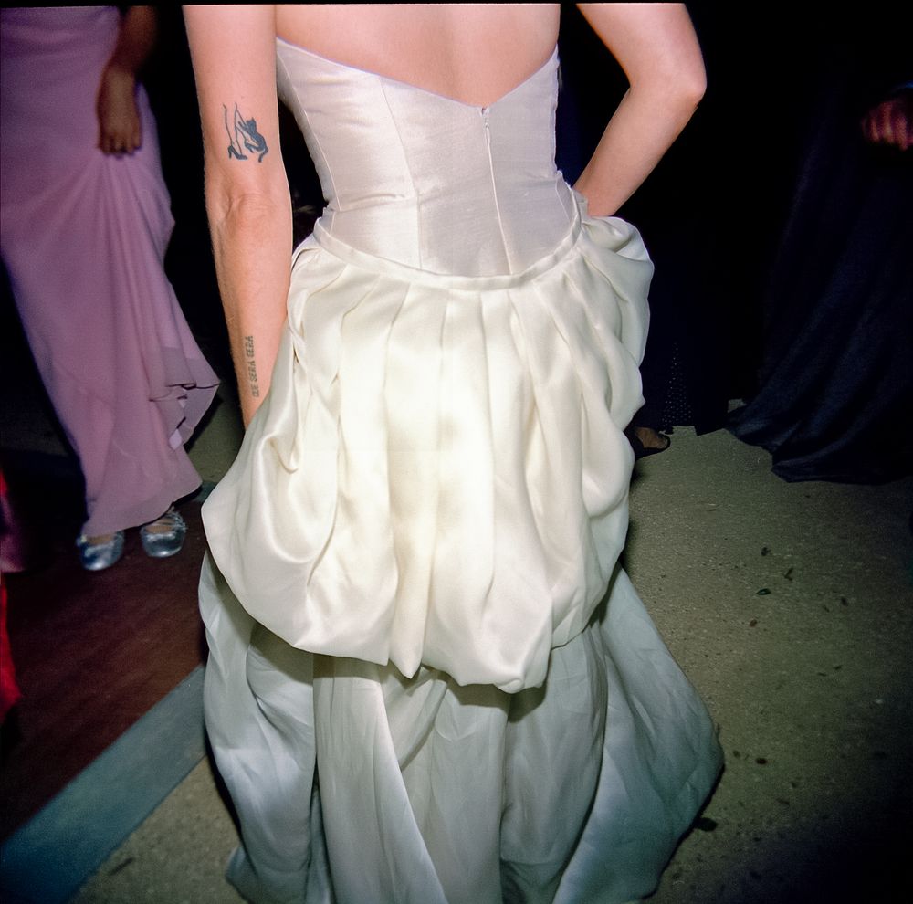 Close-up of a white wedding dress with structured corset and flowing skirt details.