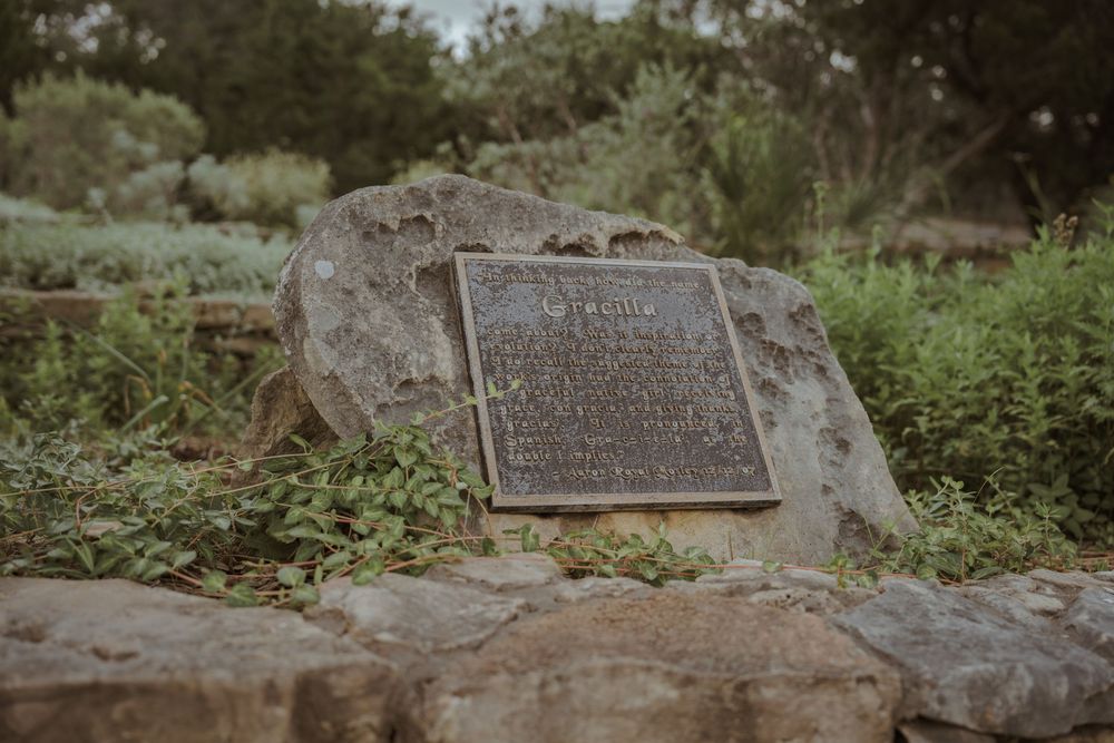 Historic memorial plaques and markers set among natural vegetation.