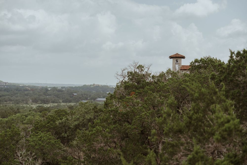 Panoramic hilltop view of a desert landscape with buildings in the distance.