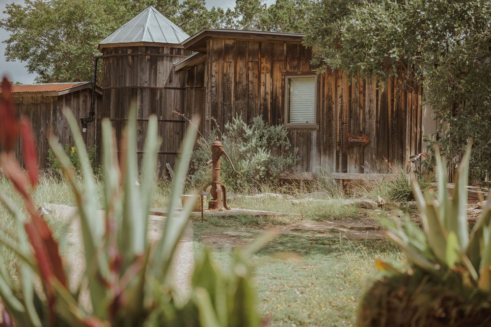 Rustic wooden barn and green landscaping at an outdoor wedding venue.