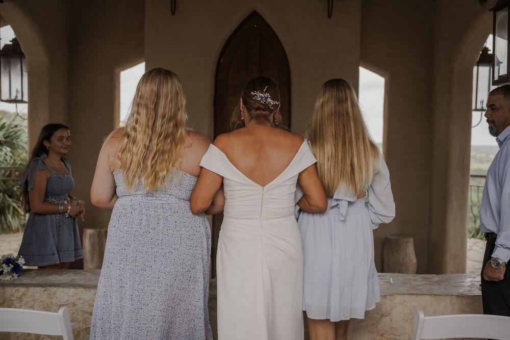 Bridesmaids in matching lavender dresses stand together during a wedding celebration.
