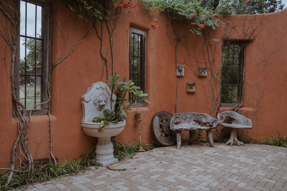 A terracotta colored wall with windows and climbing vines creates a Mediterranean atmosphere.