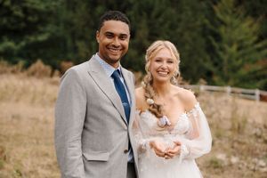 A couple shares a joyful moment with an alpaca during their outdoor wedding photoshoot.