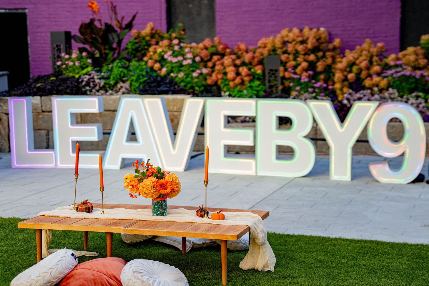 Illuminated marquee letters spelling out text against a dark background with string lights.